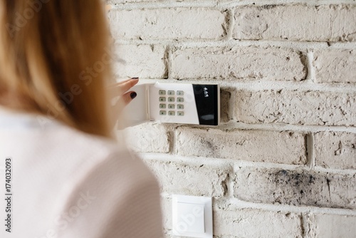 Obraz na płótnie Woman entering password on home alarm keypad. w salonie