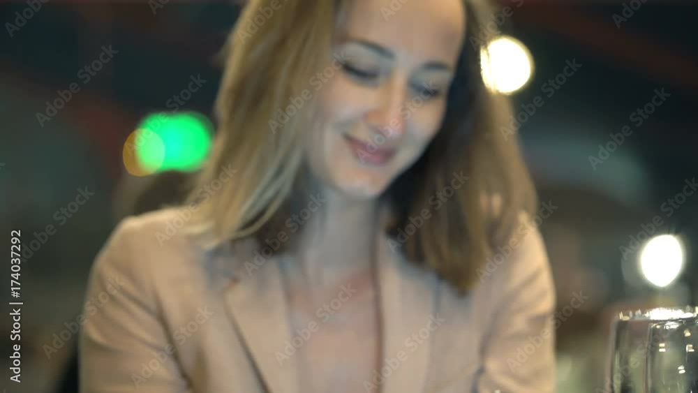 Young woman browsing Internet on smartphone in cafe at night
Young woman browsing Internet on smartphone in cafe at night