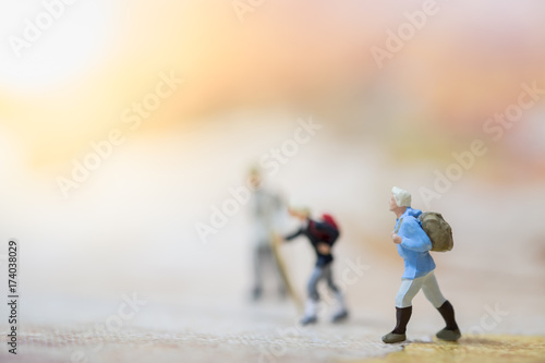 Travelling concepts. Group of traveler hiking  miniature mini figures with backpack  walking on map