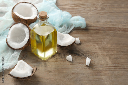 Bottle with fresh coconut oil on wooden table