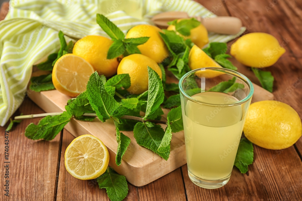 Beautiful composition with glass of fresh lemon juice on table Beautiful composition with glass of fresh lemon juice on table