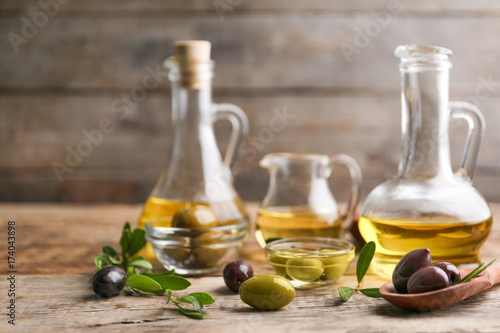 Composition with healthy olives and oil on wooden table