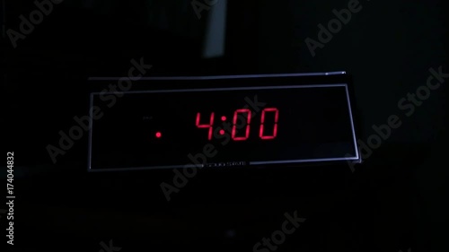 A man gropes for the alarm clock at 4:00 AM