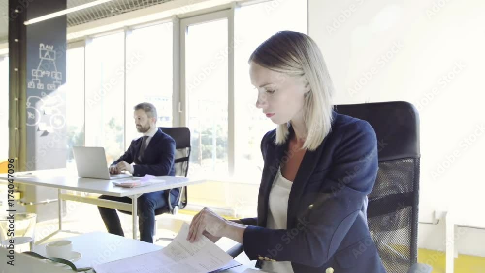 Two business people in the office working together. Two business people in the office working together.