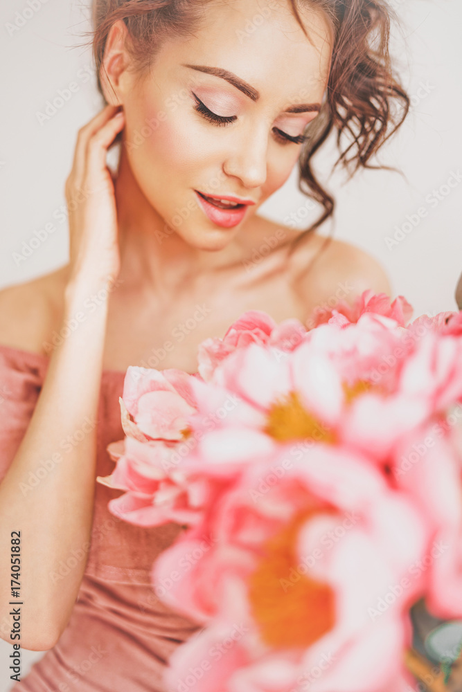 Beautiful young woman with bouquet of peony