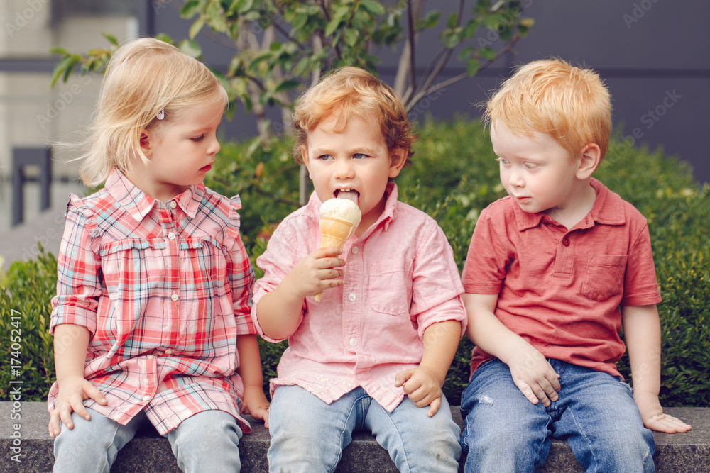 Group portrait of three white Caucasian cute adorable funny children  toddlers sitting together sharing ice-cream food. Love friendship jealousy  concept. Best friends forever. Stock Photo | Adobe Stock
