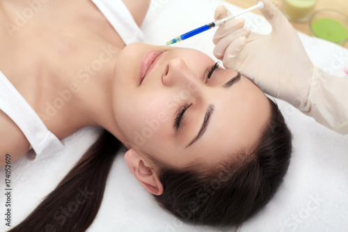 Woman gets injection in her face. Beauty woman giving injections. Young woman gets beauty facial injections in the cosmetology salon. Face aging injection. Aesthetic Medicine  Cosmetology