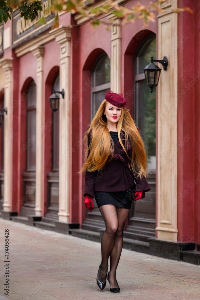 The sexy girl with long red hair walk outdoor in the autumn day. The girl in red gloves. The sexy girl with long red hair walk outdoor in the autumn day. The girl in red gloves.