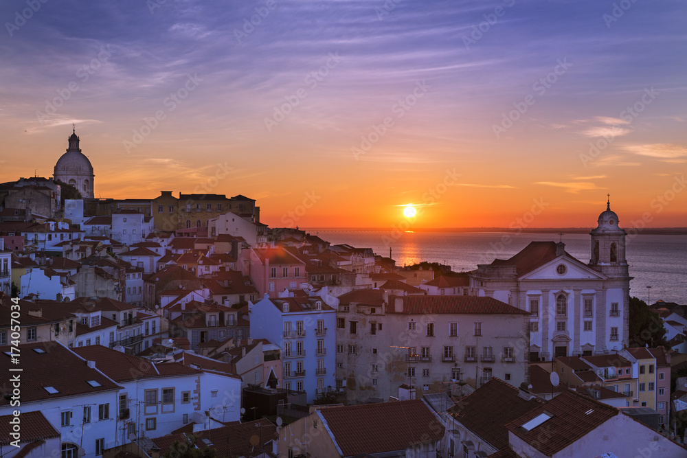 View of the Alfama neighborhood from the Portas do Sol viewpoint at sunrise in Lisbon, Portugal; Concept for travel in Portugal