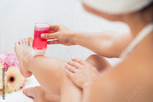 Foto Close-up of the hand of a young woman using a modern recharchable roll-on waxer