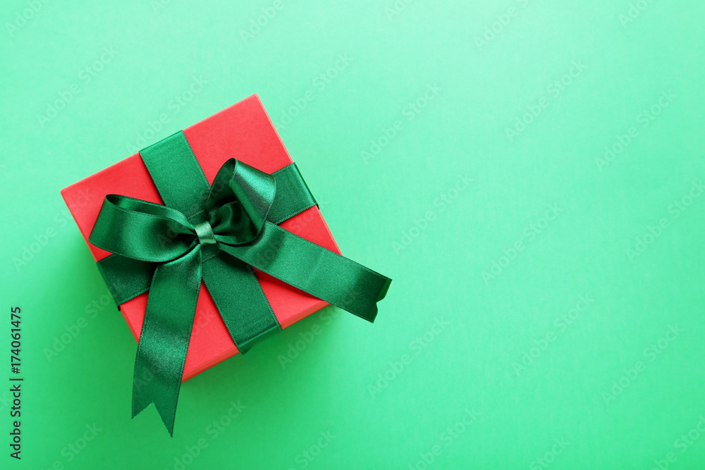 Gift box with ribbon on green background Gift box with ribbon on green background