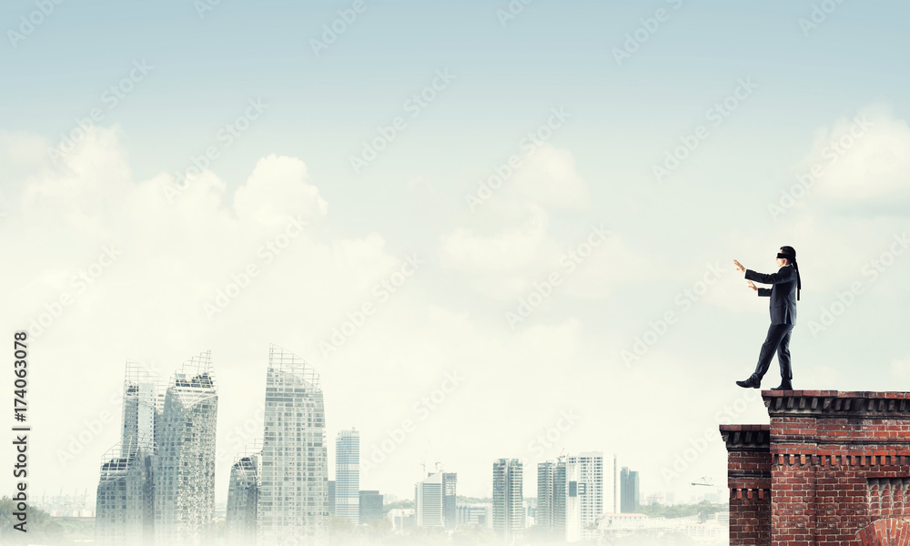 Danger and risk concept with businessman making step from edge Danger and risk concept with businessman making step from edge