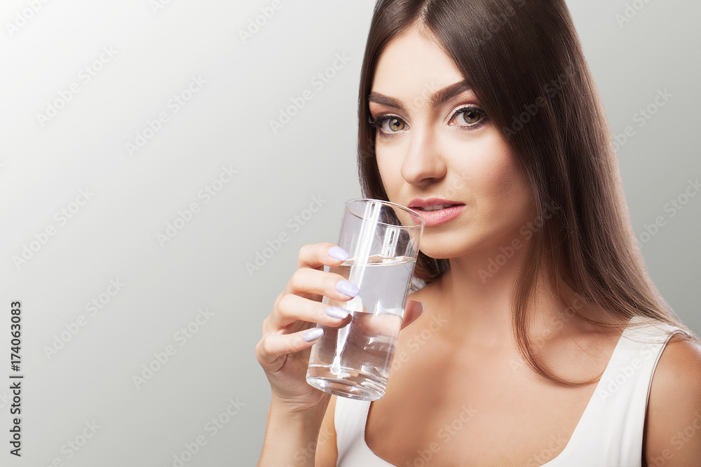 Drink water from the glass. Healthy Lifestyle. Portrait of a happy young woman with a glass of fresh water. Health. Drinks Beauty. The concept of diet. Healthy Eating. Drink water from the glass. Healthy Lifestyle. Portrait of a happy young woman with a glass of fresh water. Health. Drinks Beauty. The concept of diet. Healthy Eating.