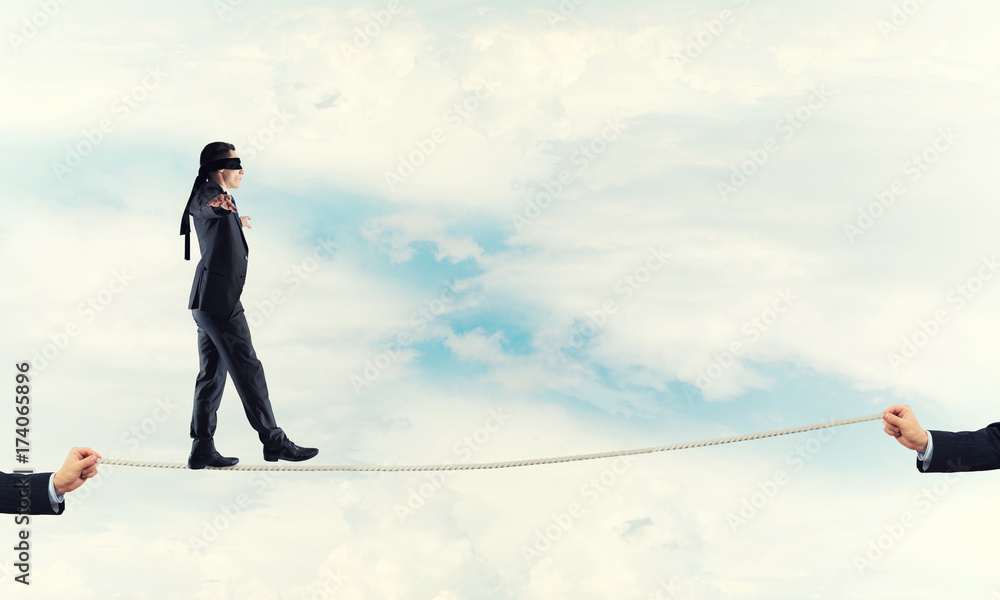 Business concept of risk support and assistance with man balancing on rope Business concept of risk support and assistance with man balancing on rope