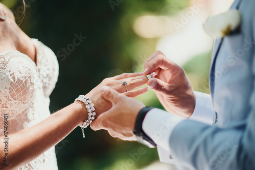 Newly wed couple's hands with wedding rings. Newlyweds put wedding wedding gold rings. Bride and groom's hands with wedding rings