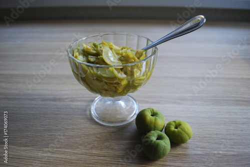 Jam from slices of Chaenomeles japonica (known as Maule's quince) green and yellow fruits in the glass bowl.