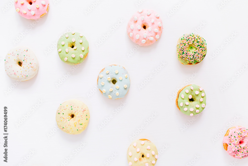 Colorful donuts on white background. Flat lay, top view minimal pattern. Colorful donuts on white background. Flat lay, top view minimal pattern.