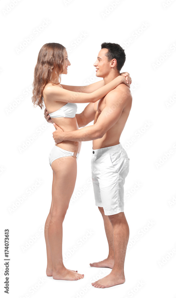 Young couple in beachwear hugging on white background Young couple in beachwear hugging on white background