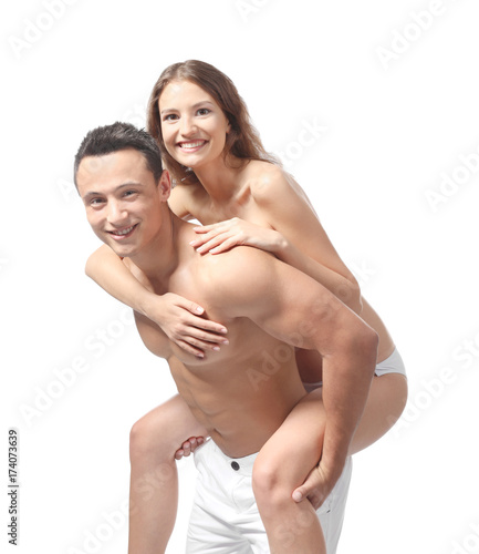 Young couple in beachwear playing on white background