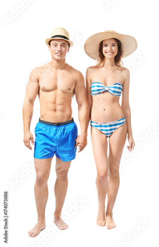 Young couple in swimsuits on white background