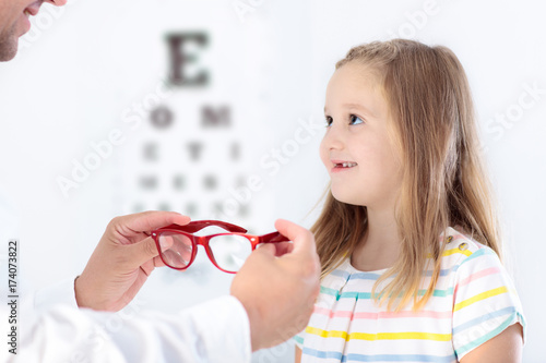 Child at eye sight test. Kid at optitian. Eyewear for kids. photo