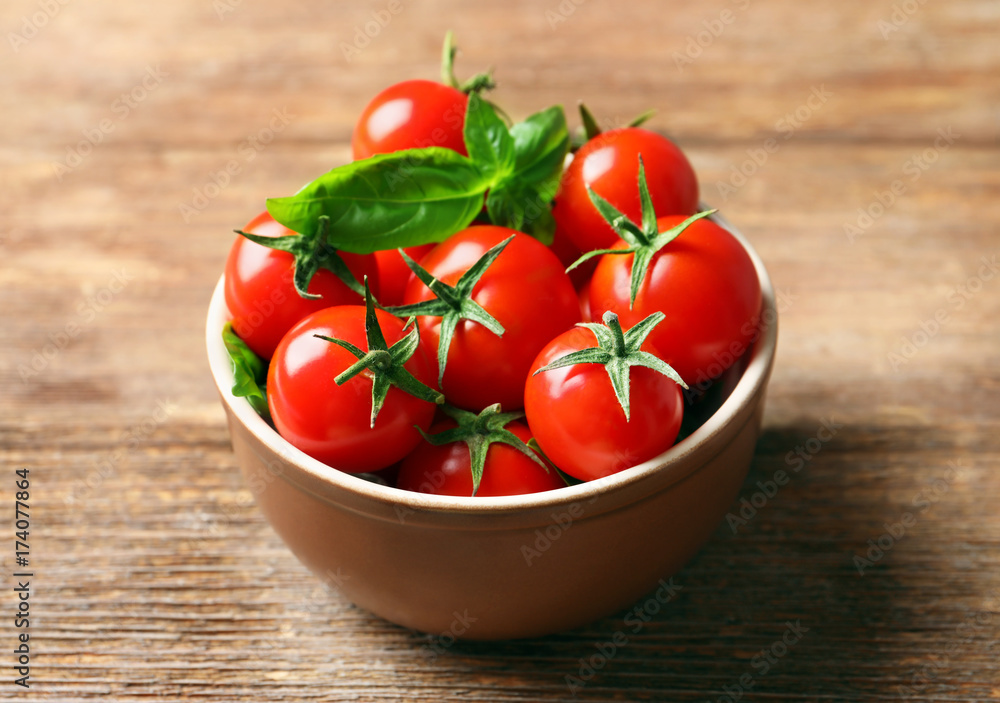 Bowl with fresh cherry tomatoes on wooden table