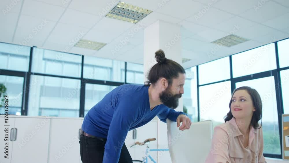 Cheerful creative design team working at their desks in modern office Cheerful creative design team working at their desks in modern office