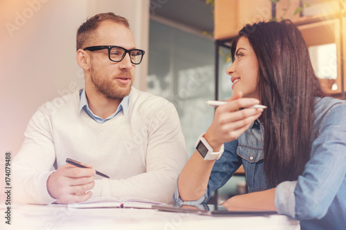 Cheerful coworkers discussing business project