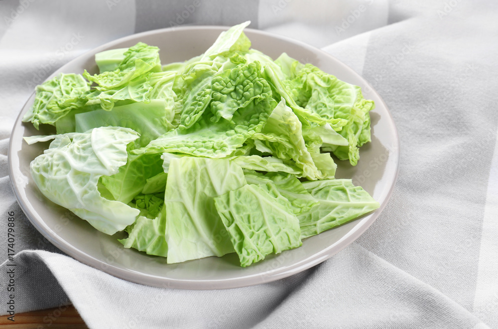 Plate with fresh green cabbage leaves on table Plate with fresh green cabbage leaves on table