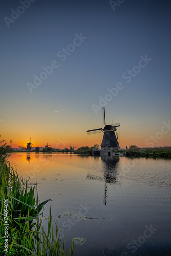 Travelling Concepts and Ideas. UNESCO Heritage Dutch Windmills In Front of The Canal and Sun at Kinderdijk Located in Traditional Village in Holland, The Netherlands.
