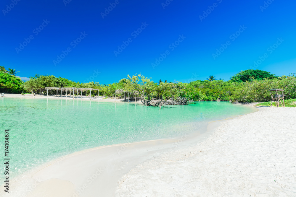 great amazing inviting view of tropical white sand beach and tranquil turquoise ocean lagoon on blue sky background at Cayo Coco Cuban island, sunny summer beautiful day