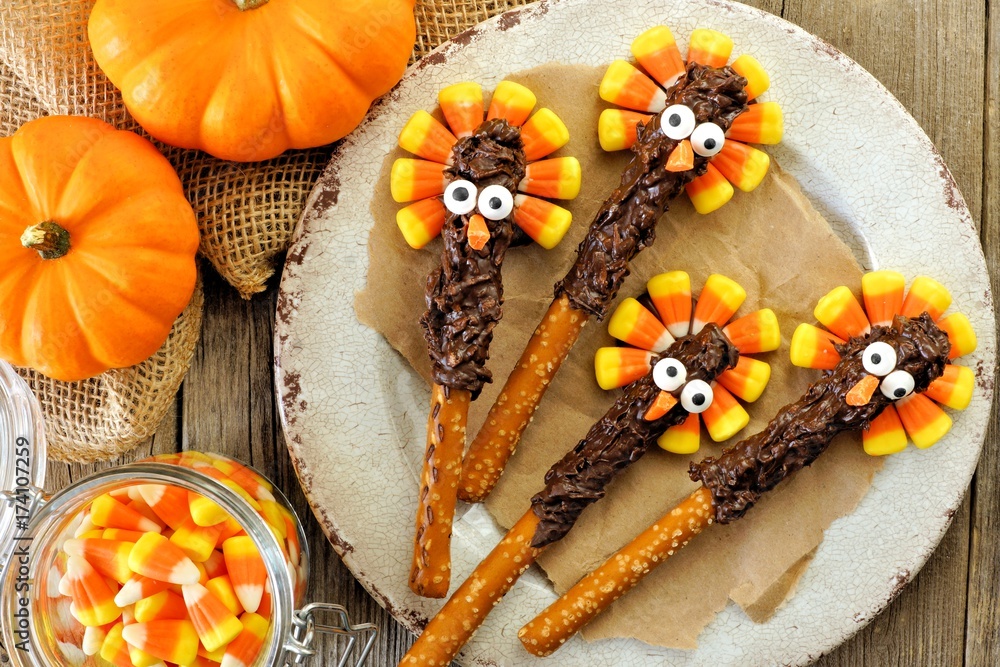 Funny Thanksgiving turkey pretzel rods with candy corn, overhead scene on old wood Funny Thanksgiving turkey pretzel rods with candy corn, overhead scene on old wood