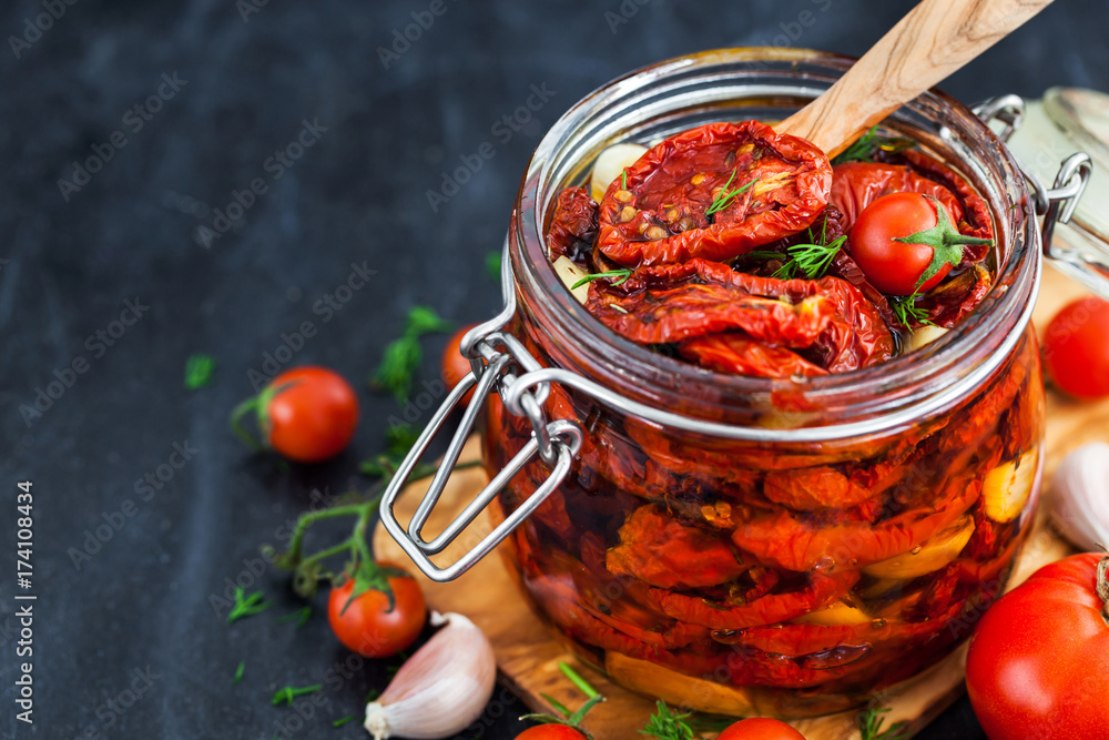 Sun dried tomatoes with garlic and olive oil in a jar - obrazy, fototapety, plakaty 