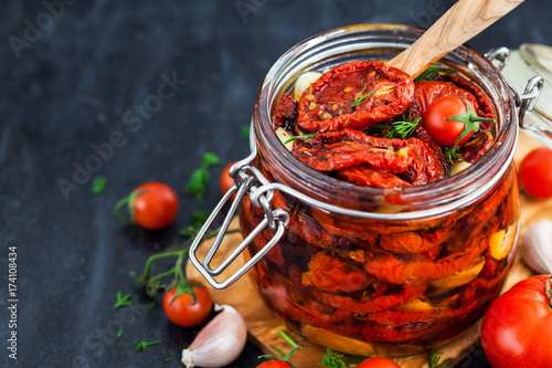Sun dried tomatoes with garlic and olive oil in a jar photo