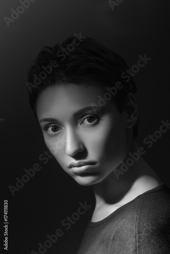 portrait of beautiful sensual woman looking at camera on dark background 