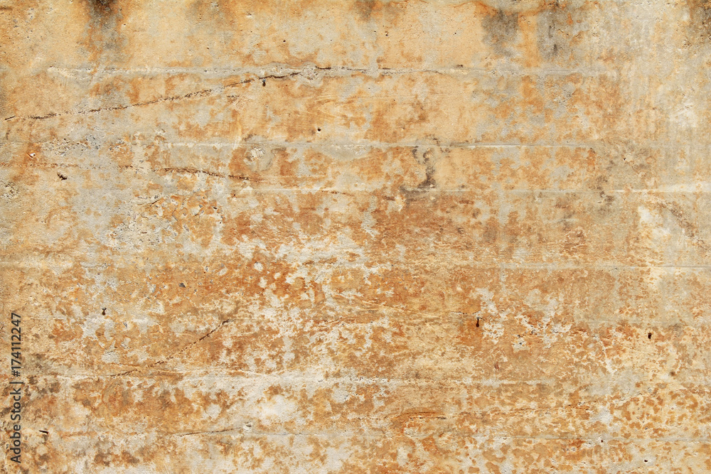 Weathered and stained orange plaster block wall
