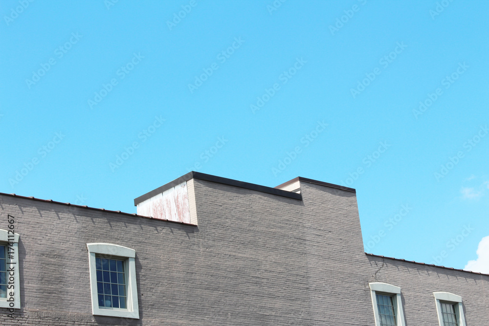 Stepped top of a commercial building with a row of windows

