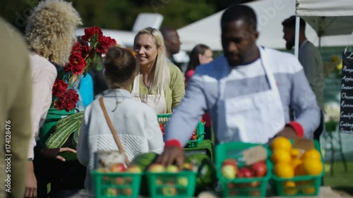  Friendly stall holders selling fresh produce to customers at farmers market
