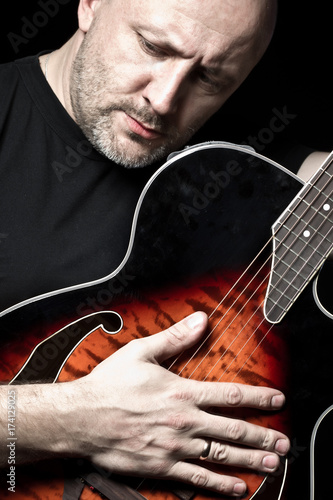 The man tunes the guitar to...