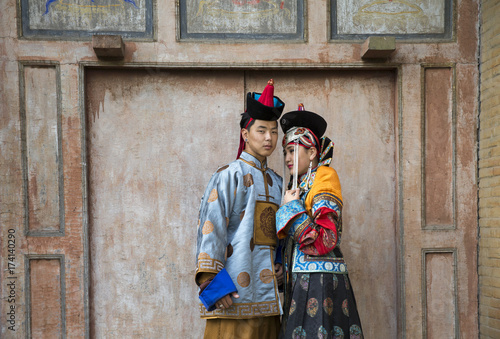 mongolian couple in traditional 13th century style outfit walking near old temple
