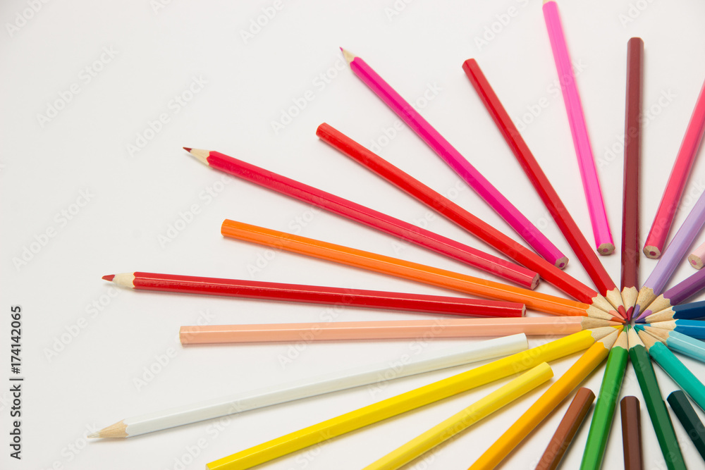 A group of pencils folded in rainbow colors in a circle on a white background A group of pencils folded in rainbow colors in a circle on a white background