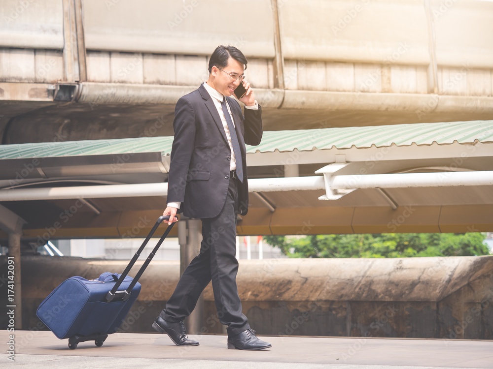 Portrait middle aged asian businessman 40s in the city, businessman, manager, boss handsome looking talking on the phone and holding bag in the city concept. Portrait middle aged asian businessman 40s in the city, businessman, manager, boss handsome looking talking on the phone and holding bag in the city concept.