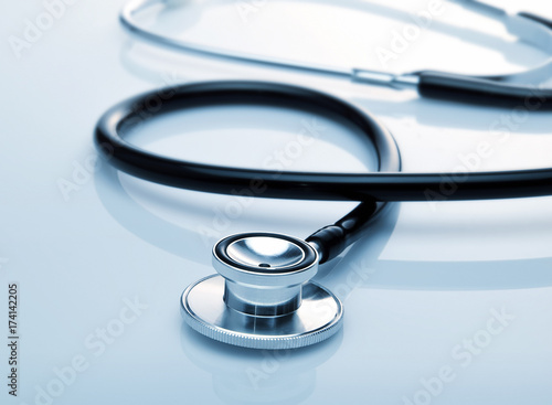 Stethoscope with reflection on glossy background.