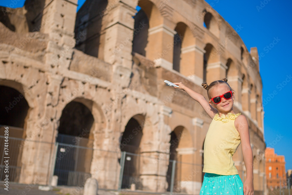 Adorable little girl having fun background of Colosseum in Rome, Italy.