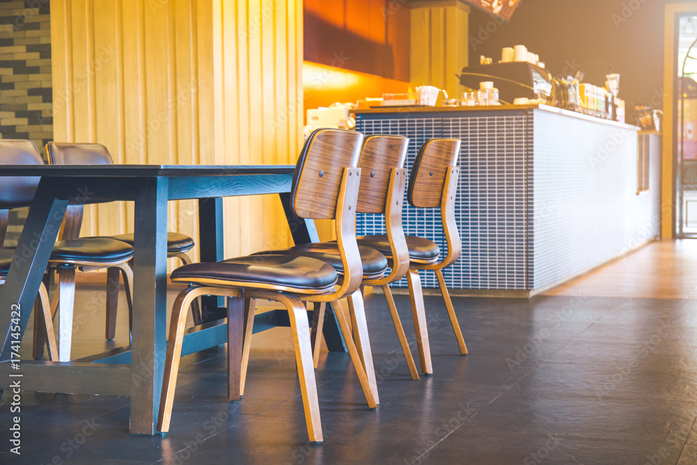 Table and wooden chairs in a modern coffee shop.