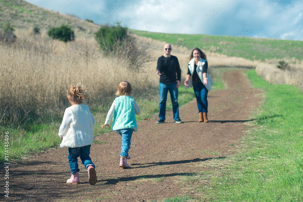 Happy family of four hiking in the park with beautiful view Happy family of four hiking in the park with beautiful view