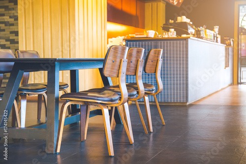 Table and wooden chairs in a modern coffee shop.