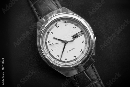 Black and white retro men wrist watch on black leather background.Old men wrist watch