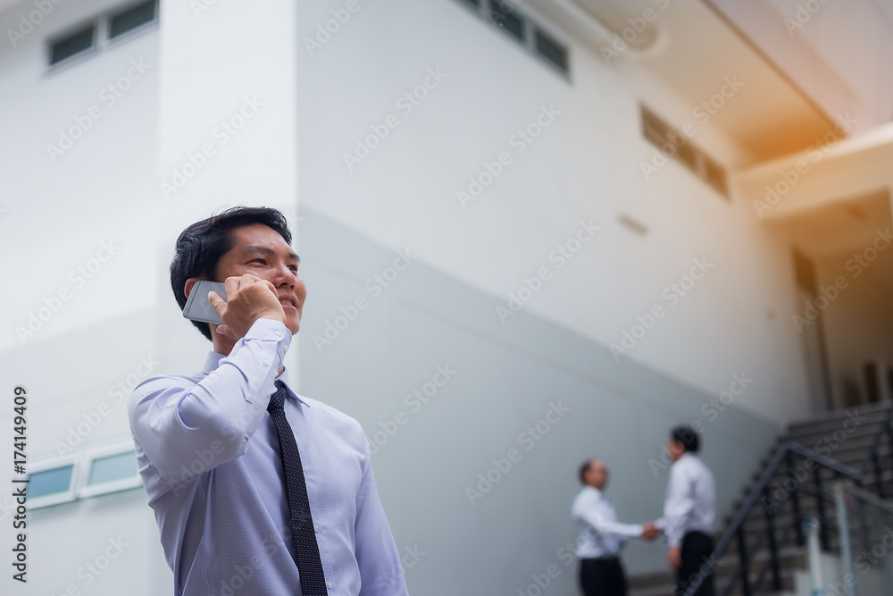 Portrait of a handsome young businessman who is negotiating a business on a mobile phone and negotiating a deal.
