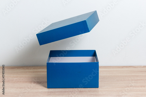 Blue open gift box on wooden table background